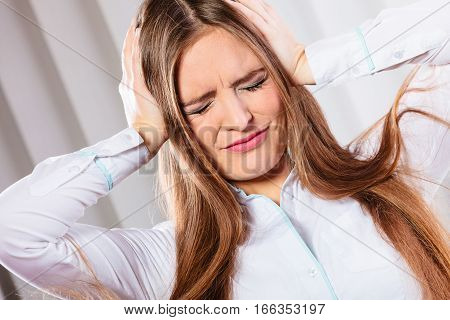 Stressful situations in work. Headache and migraine. Young woman in office pain and emotions.