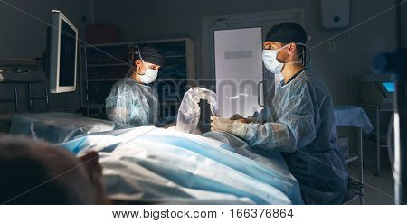 doctor and an assistant in the operating room for surgical venous vascular surgery clinic