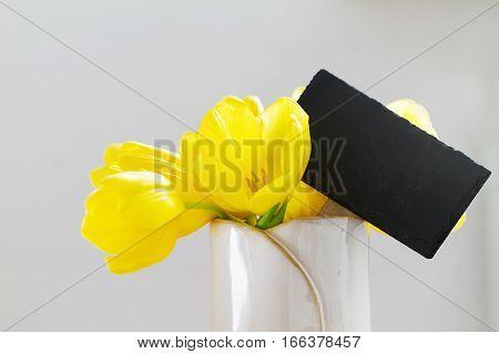 Beautiful Fresh Spring Yellow Tulips in Vase on bright background. Spring easter or Mother's Day Concept.