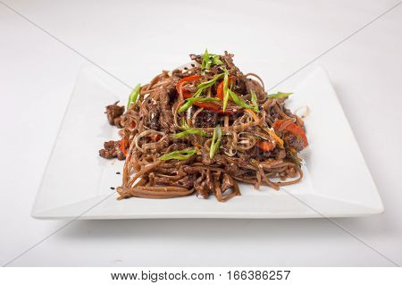 Soba Buckwheat noodles with chicken teriyaki on a white background