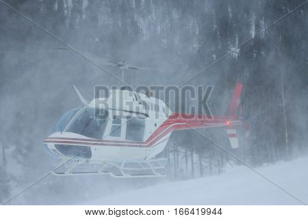 The Helicopter Landed In The Mountains In Winter, Raising A Cloud Of Snow