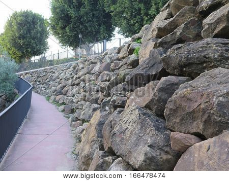 Retaining wall from rough granite blocks in residential street in Alora Andalucia