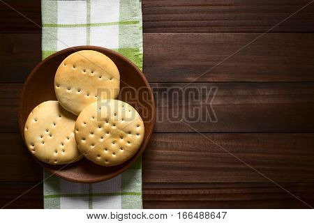 Traditional Chilean Hallulla bread rolls on rustic plate photographed overhead on dark wood with natural light