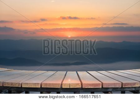 Selective foucus on Empty wooden table with the sunrise mountain view background. For display or montage your products.