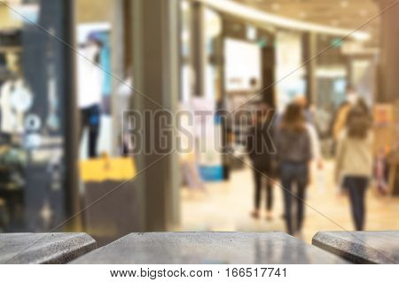 Selective foucus on Empty wooden table with the shopping mall have laday shopping background. For display or montage your products.
