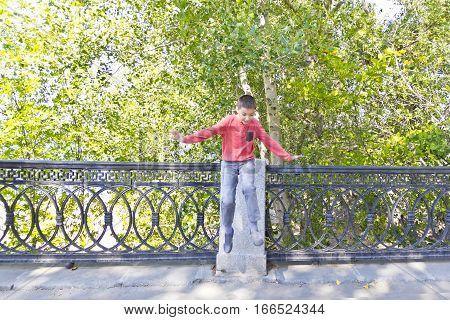 Boy are jumping on embankment in summer
