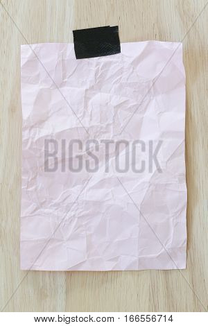 Pink notepad paper crumpled of empty and copy space on wooden backgroundYou can input the message text in picture.
