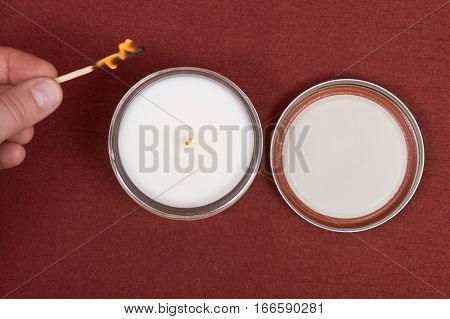 Soy candle in glass jar on red fabric background