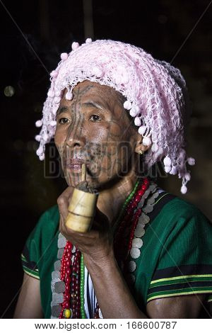 Chin region Myanmar November 11 2014: muun tribe chin lady smoking a pipe