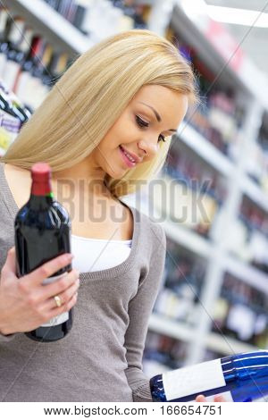 Portrait of a Woman Choosing Wine Bottles in a Supermarket
