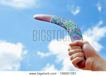 Wooden Boomerang with Blue Sky and Cloud Background
