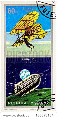 MOSCOW RUSSIA - January 25 2017: A stamp printed in Fujeira shows spacecraft Luna 10 and ancient glider (1852) series "Air and Space Vehicles" circa 1971