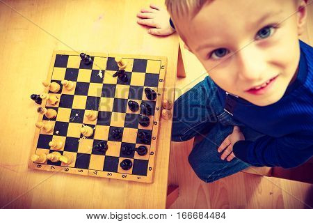 Intelligent smart ass kids games good for brain intelligence concept. Young kid boy playing chess and having fun.