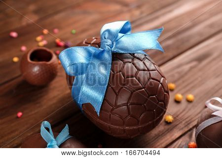 Chocolate Easter eggs with color ribbon bow on wooden background