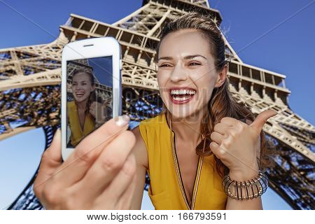 Woman Taking Selfie With Phone In Front Of Eiffel Tower In Paris