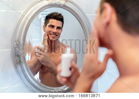 Healthy Positive Male Treating Sking With Lotion