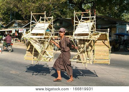Thazi Myanmar - 11 January 2010: Man carrying bamboo chairs and tables on the street of Thazi on Myanmar