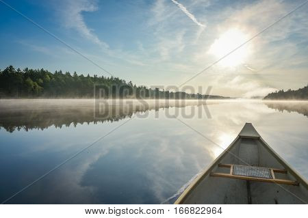 Canoe trip in the morning.  Brilliant and bright mid-summer sunshine morning, paddling a canoe in the middle of quiet, calm and peaceful Corry lake.