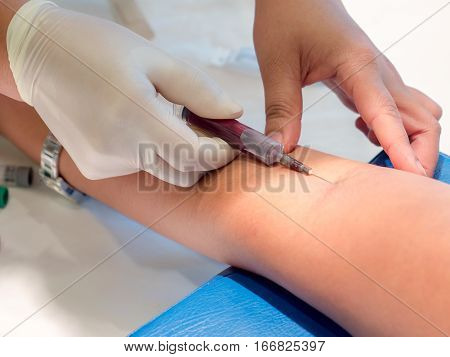 Nurse taking Real Blood samples (Phlebotomist) for analysis from a patient (Selective focus)