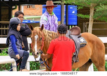 Tuaran,Sabah,Malaysia-Jan 22,2017:Visitor ready to riding a horse in Sabandar Leisure Rides,it is Sabah's attraction for lovers of the Wild West who want to experience horse riding within a paddock