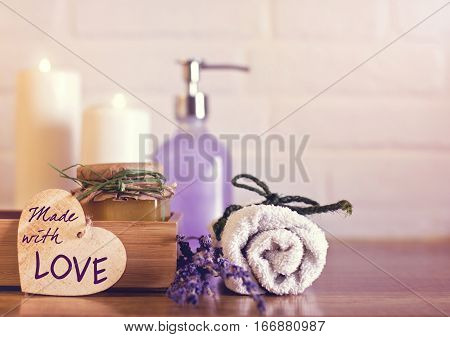 Spa And Wellness Setting With White Towels , Sponge, Candle, Lavender And Wooden Heart On Bricks Wal