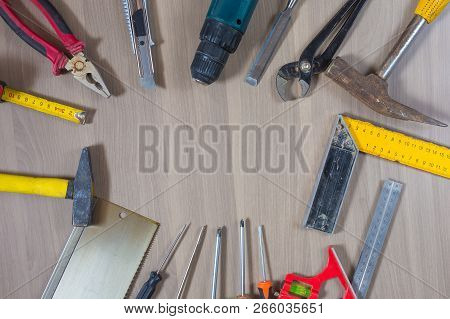 Different Tools On A Wooden Background. Hammer, Drill, Pliers. Screwdriver, Ruler, Cutting Pliers