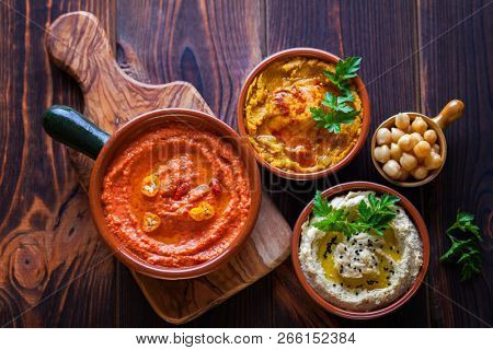  pumpkin hummus red pepper hummus and lentils hummus on wooden table