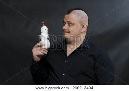 Subculture Punk. Iroquois. Goths. In The Right Hand Of A Young Man A Santa Clauss Christmas Tree Toy