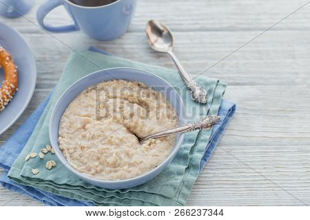 Oatmeal Porridge Bowl On The White Wooden Background. Healthy Nutritious Breakfast. Concept Of Healt