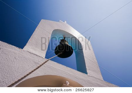 zvon belltower bílého kostela řeckého proti modré obloze