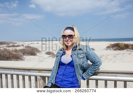 Blonde Female Poses At A Beach Boardwalk Platform In Assateague Island Maryland
