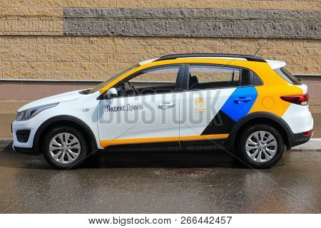 MOSCOW - MAY 1, 2018: Wet white Kia car of Moscow carsharing company Yandex Drive at sunny street, carsharing is system of short-term car rental