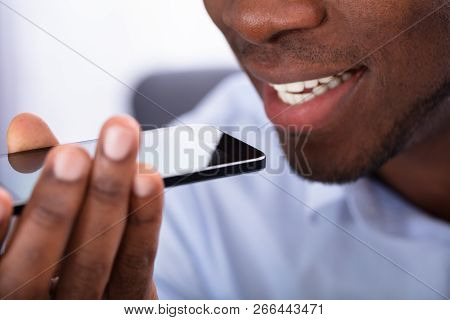 Close-up Of An African Man Using Voice Assistant On Cellphone