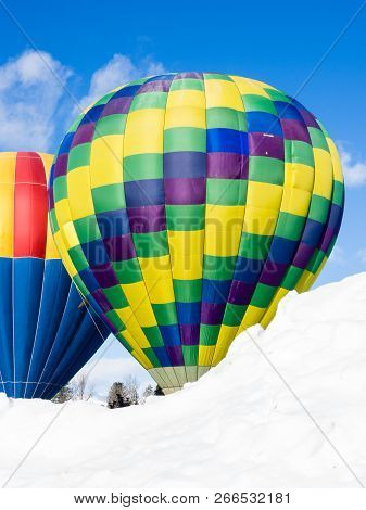 Two Colorful Hot Air Balloons On A Snowy Field Ready To Take Off - At Winthrop Balloon Festival, Was