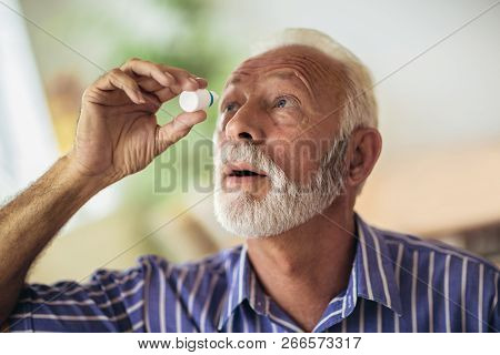 Elderly Person Using Eye Drops At Home