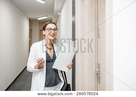 Portrait Of An Excited Woman With Key And Documents Standing Near The Dooor Of The New Apartment In 