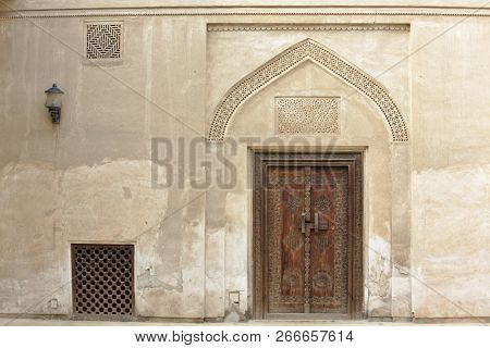 Carved wooden door and ornate doorway in a courtyard of traditional Arabian house of pearl trader Shaikh Isa bin Ali, Muharraq, Bahrain