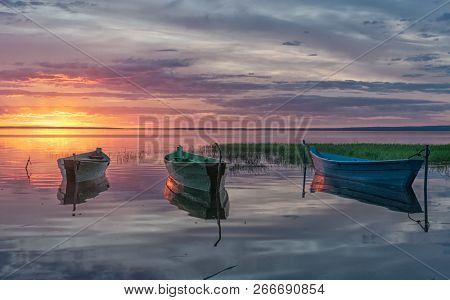 Sunset Rays Reflected From Wooden Boats In The Calm Water Of A Lake Plesheevo In Pereslavl Zalessky