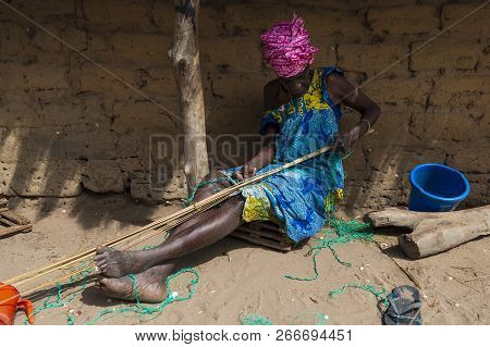 Orango Island, Guinea-bissau - February 3, 2018: An Old Woman Working In Front Of Her Hut At The Vil