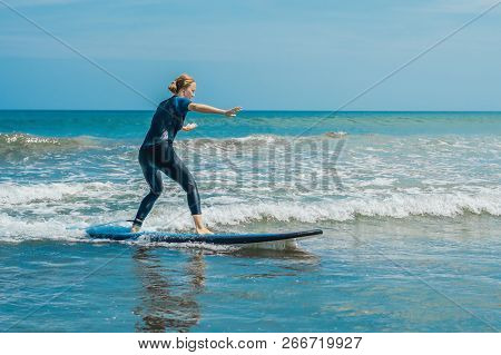 Joyful Young Woman Beginner Surfer With Blue Surf Has Fun On Small Sea Waves. Active Family Lifestyl