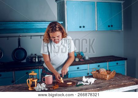 Sick Blonde Girl Is Cutting Lemon With A Knofe In The Blue Kitchen. Used Tissues, Tablet Packs, Pink