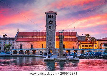 Rhodes, Greece. Stunning Sunset Image Mandraki Harbour And Evaggelismos Church The Place Of Colossus