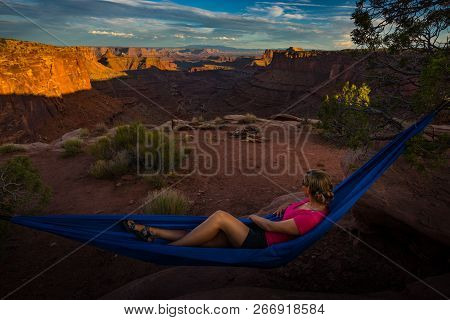 Hiker Rests On A Hammock Admiring The Sunset East Fork Shafer Canyon Near Dead Horse Point State Par