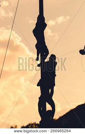 Silhouette Burmese Man Climbing Pole On End Of Buddha Day