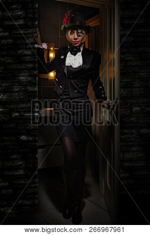 One-eyed Countess with a bandage in a black hat opening the door