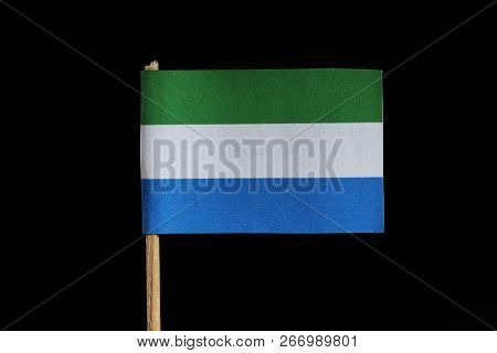 A National Flag Of Sierra Leone On Toothpick On Black Background. A Horizontal Tricolour Of Light Gr