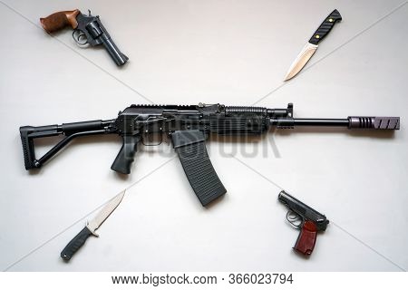 Close-up Of A Boar Machine Gun, Army Knives And Pistols On A Gray Background. Isolated. Flat Lay.
