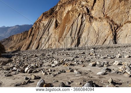 The Dry Bed Of A Mountain River In The Himalayas. Stones In The Sand At The Bottom Of The River In T