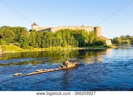Beautiful Amazing Sunner Landscape. Birch Grows On Stones Among The Narva River Against The Backgrou