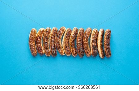 Above View With Grilled German Sausages, Alligned On A Blue Background. Authentic Grilled Nuremberge